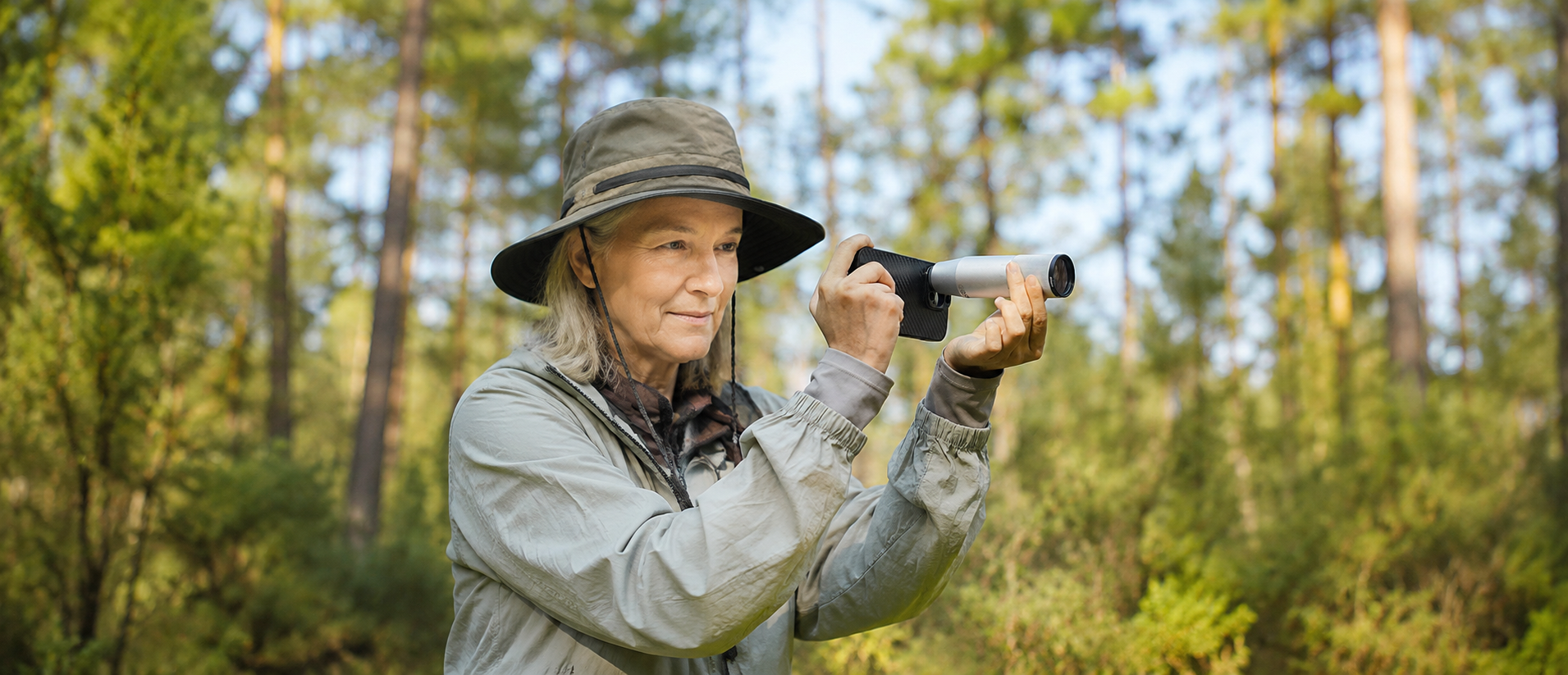 Birder in Canadian forest using telephoto lens on iPhone